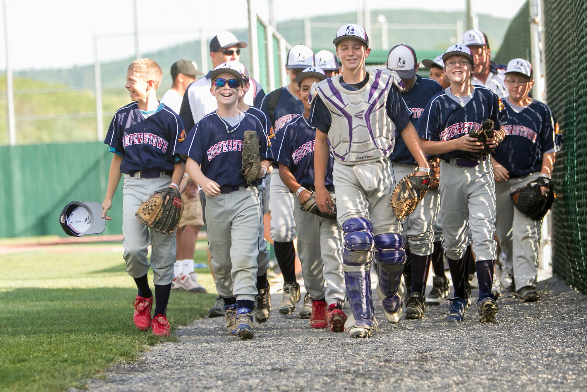 children from the Cooperstown baseball team walking after the game